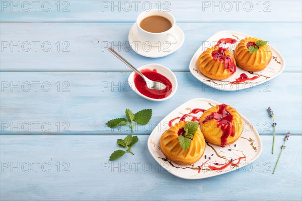 Semolina cheesecake with strawberry jam, lavender, cup of coffee on blue wooden background. side view, copy space
