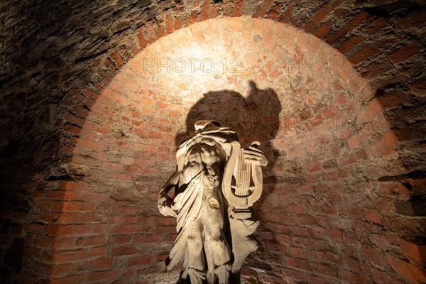 Statue of Apollo in a niche with dramatic shadows, historic city wall in the garden of the Moellenvogtei, Magdeburg, Saxony-Anhalt, Germany, Europe