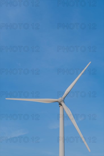 Closeup of wind turbine blades with clear blue sky in background