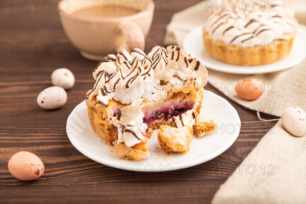 Tartlets with meringue cream and cup of coffee on brown wooden background and linen textile. side view, selective focus. Breakfast, morning, concept