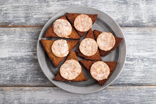 Sausage and toast on a gray plate on a gray wooden background. Top view, flat lay, close up