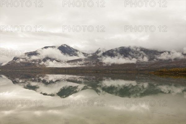 Beautiful foggy mood with lake reflection in the fjord in northern Norway Kjerringstraumen Bru Efjord