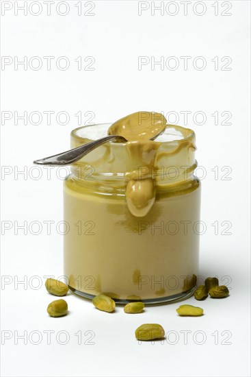 Pistachio cream in jar with spoon, pistachios