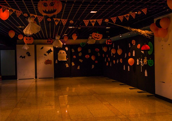Dimly lit room decorated with hand made Halloween decorations of ghost, jack-o-lanterns and balloons in South Korea