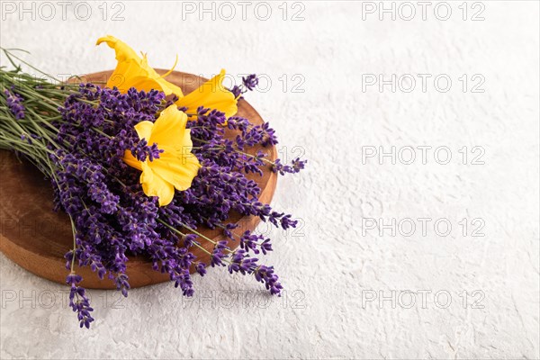 Beautiful day lily and lavender flowers on gray concrete background, side view, copy space