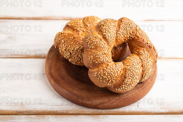 Homemade sweet bun on a white wooden background. side view, close up