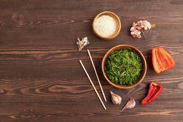 Chuka seaweed salad in wooden bowl on brown wooden background. Top view, flat lay, copy space