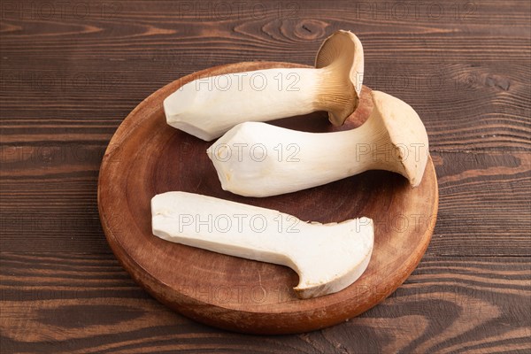 King Oyster mushrooms or Eringi (Pleurotus eryngii) on brown wooden background. Side view