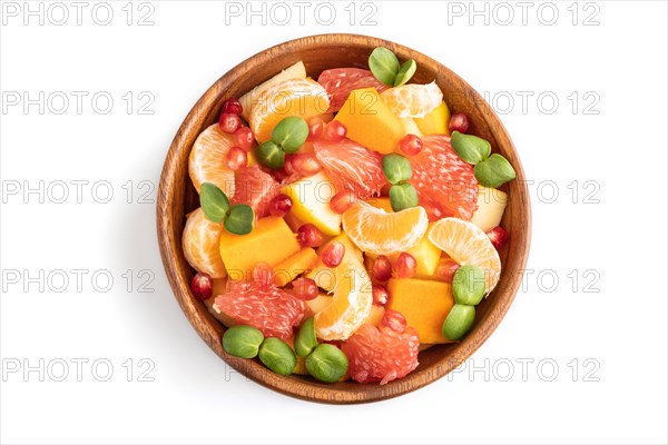 Vegetarian fruit salad of pumpkin, tangerine, pomegranate, grapefruit, sunflower microgreen sprouts isolated on white wooden background. Top view, flat lay, close up