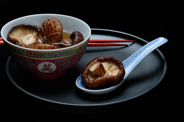 Dried shiitake mushrooms in a bowl, soaked in water