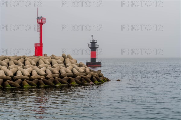 Two lighthouses at entrance to small island harbor on overcast morning in Jeju, South Korea, Asia