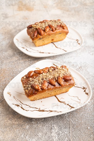 Caramel and almond cake on brown concrete background. side view, close up