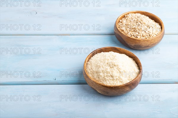 Powdered milk and oatmeal baby food mix, infant formula on blue wooden background. Side view, copy space, artificial feeding concept