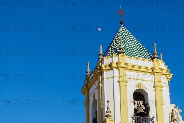 01, 22, 2024 ronda, malaga, spain Close-up of a church steeple with a blue sky and the moon in the background