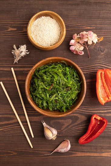 Chuka seaweed salad in wooden bowl on brown wooden background. Top view, flat lay, close up