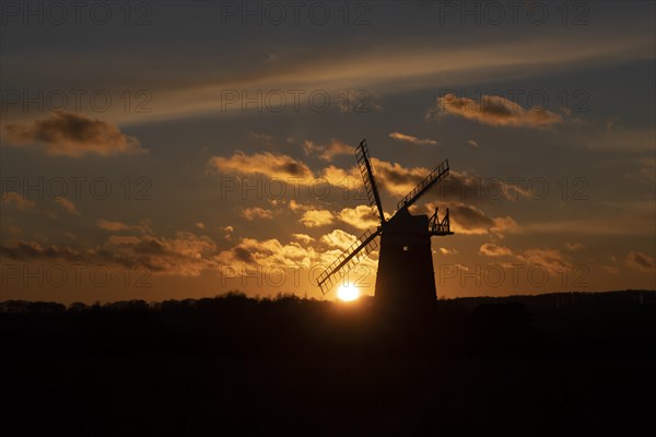 Windmill silhouetted at sunset with a red sky and clouds, Burnham Ovary Staithe, Norfolk, England, United Kingdom, Europe