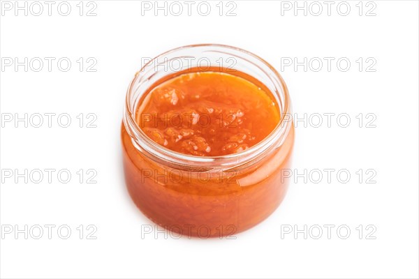 Carrot jam with cinnamon in glass jar isolated on white background. Side view, close up