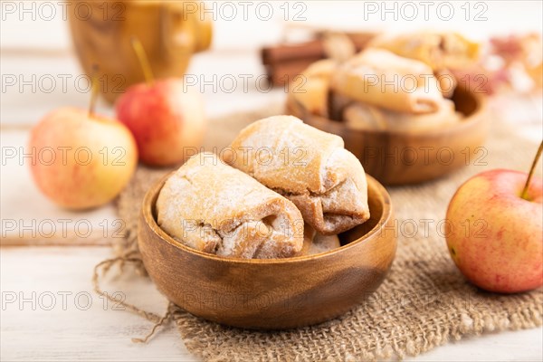 Homemade sweet cookie with apple jam and cup of coffee on white wooden background and linen textile. side view, close up, selective focus