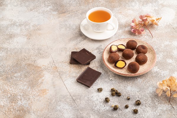 Japanese rice sweet buns chocolate mochi filled with cream and cup of green tea on brown concrete background. side view, copy space