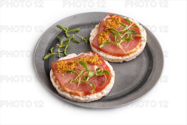 Puffed rice cake sandwiches with jerky salted meat, microgreen and mustard isolated on white background. side view, close up