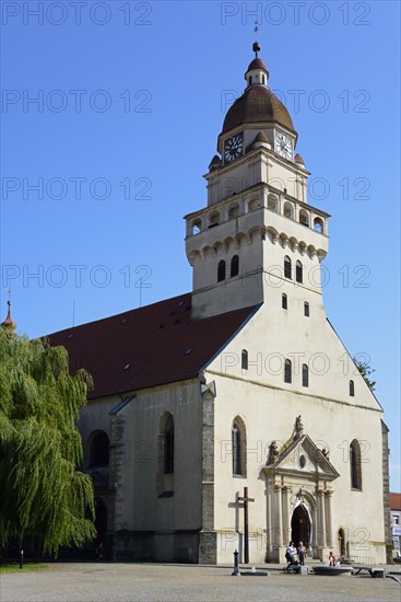 A sunny day illuminates a church with an onion dome and shade on the forecourt, Roman Catholic parish church of St Michael, Skalica, Skalica, Trnavsky kraj, Slovakia, Europe