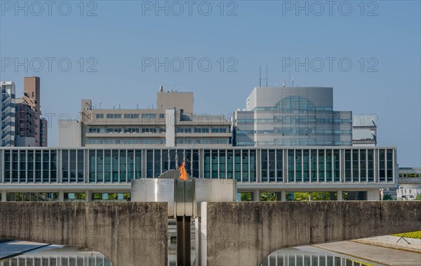 Peace Fire at Memorial Park with city buildings in background in Hiroshima, Japan, Asia