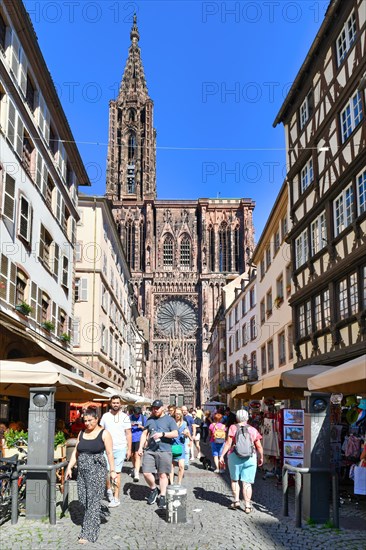 Strasbourg, France, September 5th 2023: Street with tourists in front of famous Strasbourg Cathedral in France in romanesque and gothic architecture style, Europe
