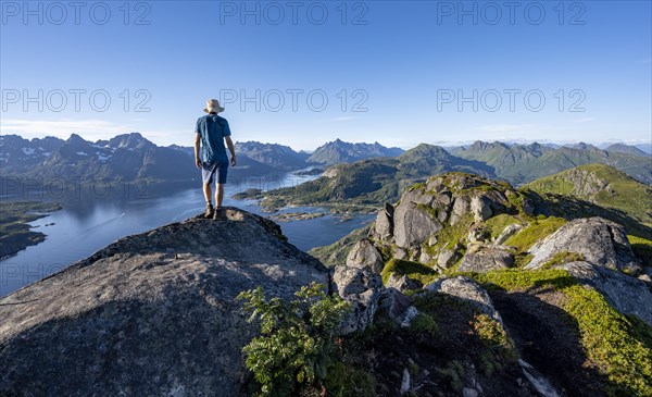 Mountaineer on the summit of Dronningsvarden or Stortinden, mountains and fjord Raftsund, Sonnenstern, Vesteralen, Norway, Europe