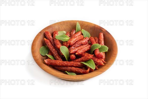 Small smoked sausage with borage microgreen isolated on white background. Side view, close up