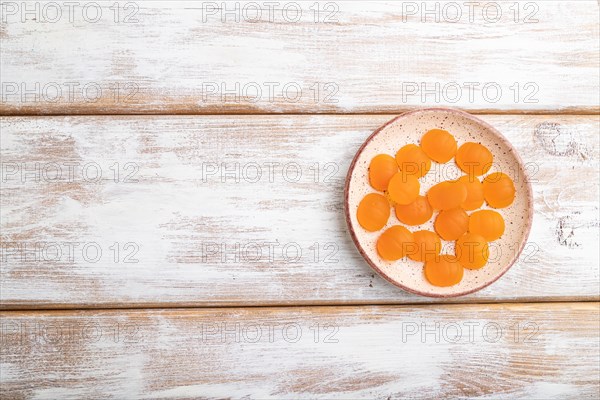Jelly pumpkin candies on white wooden background. copy space, top view, flat lay