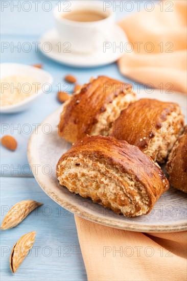 Traditional armenian dessert gata with cup of coffee on a blue wooden background and orange linen textile. side view, close up, selective focus