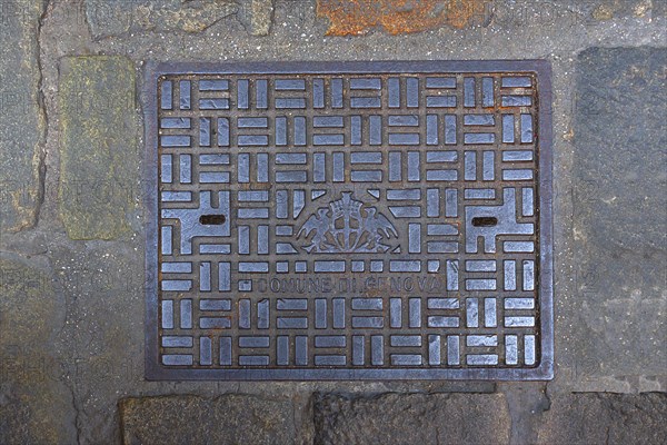 Manhole cover with the coat of arms of the city of Genoa, Italy, Europe