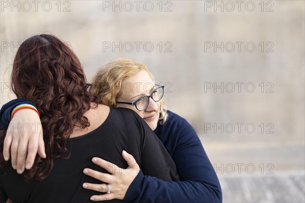 Two women hugging in the park with serious attitude