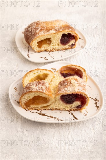 Homemade sweet bun with apricot jam on gray concrete background. side view, close up