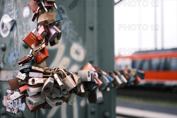 Love locks on a bridge over the Rhine, behind it a railway, blurred background, Cologne, Germany, Europe