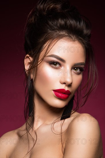 Gorgeous Young Brunette Woman face portrait. Beauty Model Girl with bright eyebrows, perfect make-up, red lips, touching her face. Sexy lady makeup for party