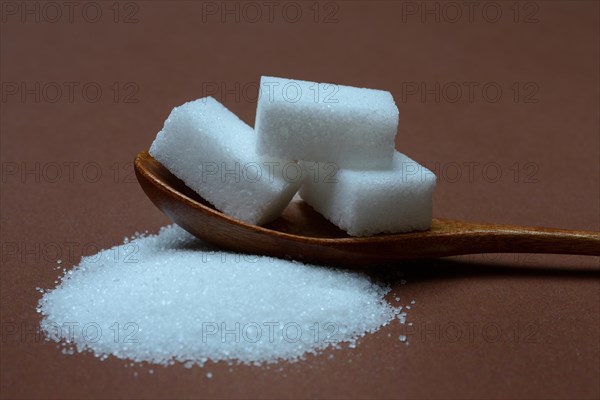 Granulated sugar and sugar cubes in spoons, sugar