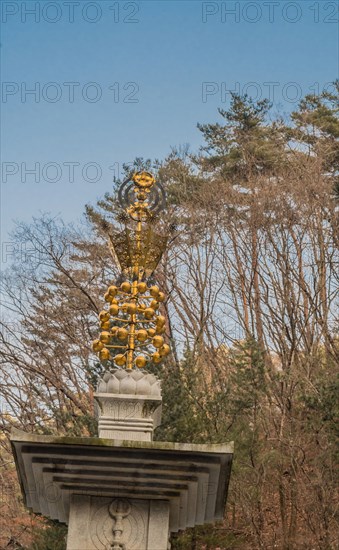 Golden ornament on top of stone carved pagoda at Buddhist temple in South Korea