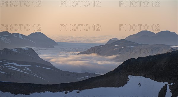 Mountain panorama with clouds in the valley, mountain peaks in soft light at sunset, view from the summit of Skala, Loen, Norway, Europe
