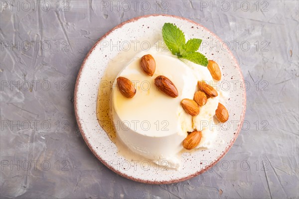 Ricotta cheese with honey and almonds on gray concrete background. top view, flat lay, close up