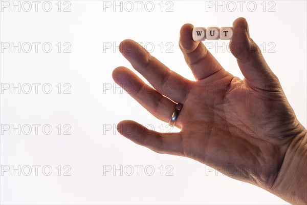 Male hand holding letter cubes forming the word anger, white background, studio shot, Germany, Europe