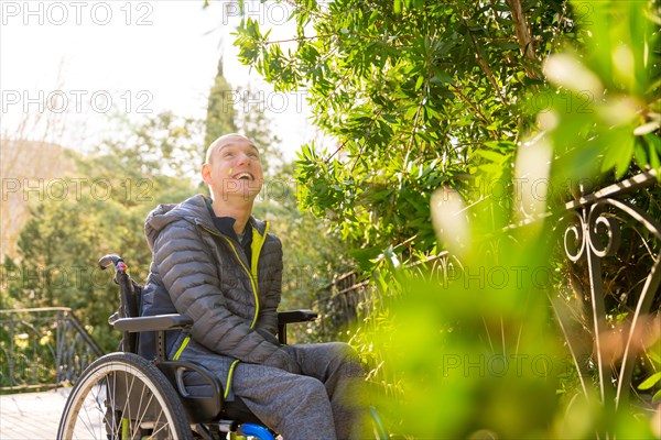 Portrait with focus and copy space of a happy disabled man gazing the nature in an urban park