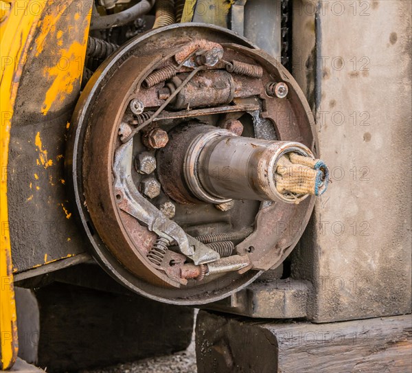 Closeup view of exposed rusty break shoe assembly and axle with dirty white cloth stuffed into open end of axle in South Korea