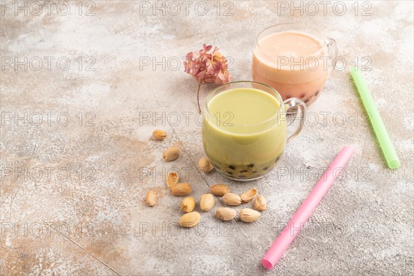 Bubble tea with pistachio and caramel in glass on brown concrete background. Healthy drink concept. Side view, copy space