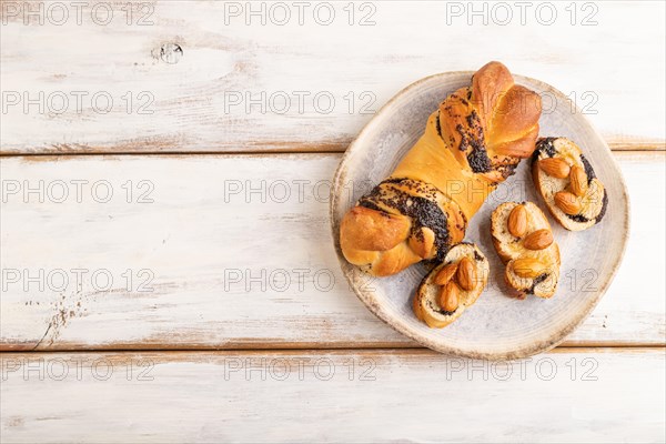 Homemade sweet bun with honey almonds on a white wooden background. top view, flat lay, copy space