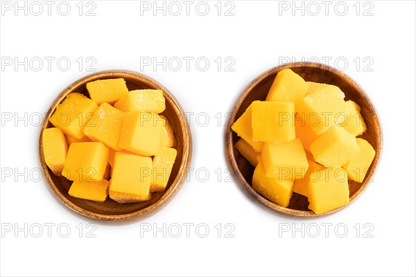 Dried and candied mango cubes in wooden bowls isolated on white background. Top view, flat lay, close up, vegan, vegetarian food concept