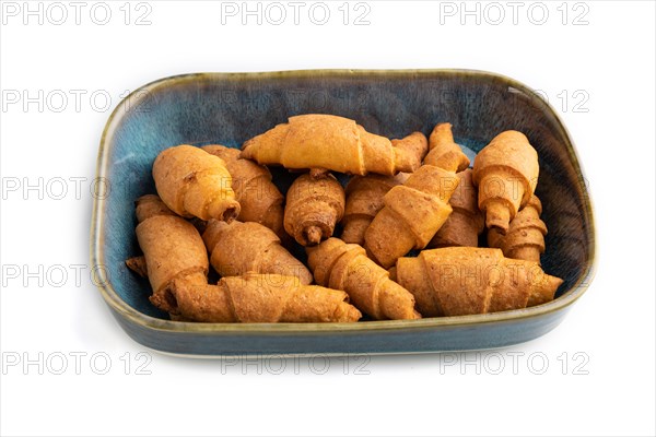 Homemade bagel roll on blue ceramic plate isolated on white background. side view, close up