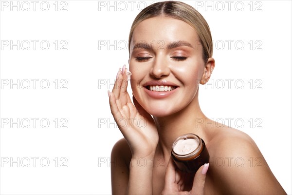 Beauty portrait of model with natural make-up holding a jar of cream. Fashion shiny highlighter on skin, sexy gloss lips make-up High quality photo