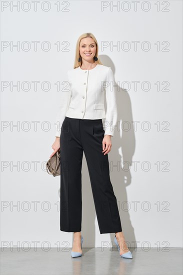 Full length portrait of stylish businesswoman in wide trousers and short blazer