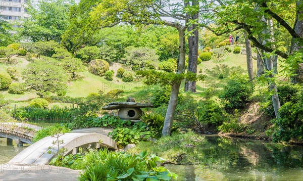 Landscape of footbridge over lake at Shukkeien Gardens in Hiroshima, Japan, Asia